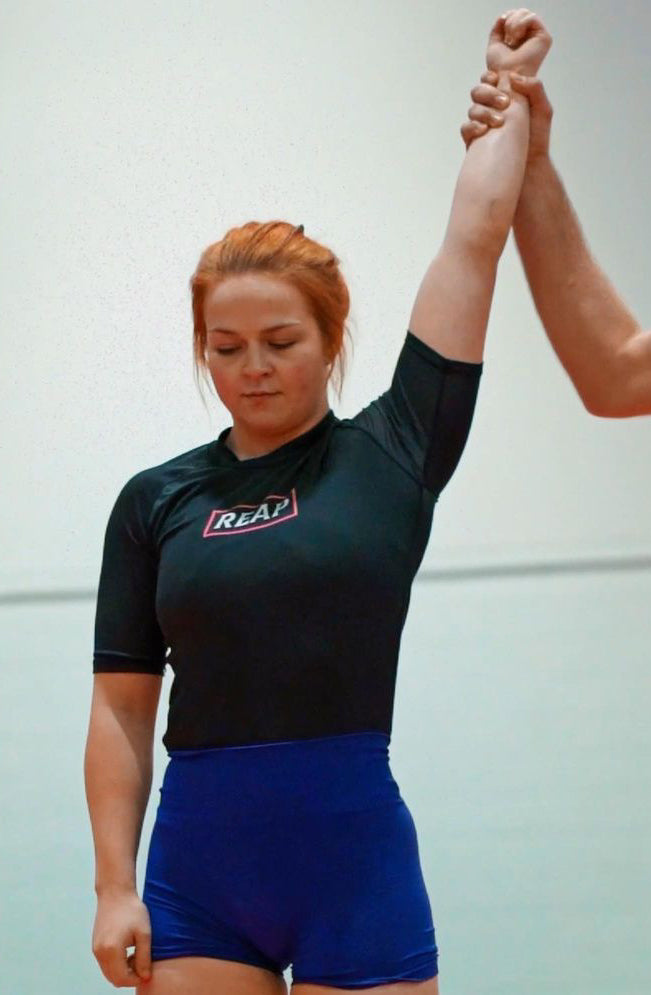 Scarletts hand raised in BJJ comp