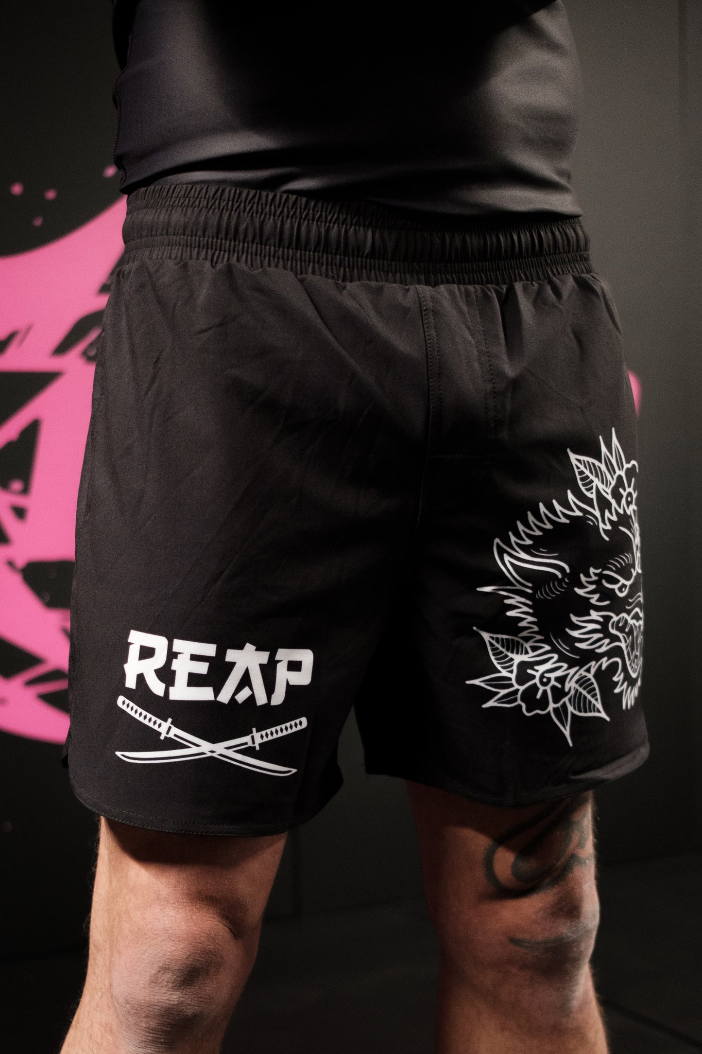Black shorts with white graphics and 'REAP' branding on a dark background