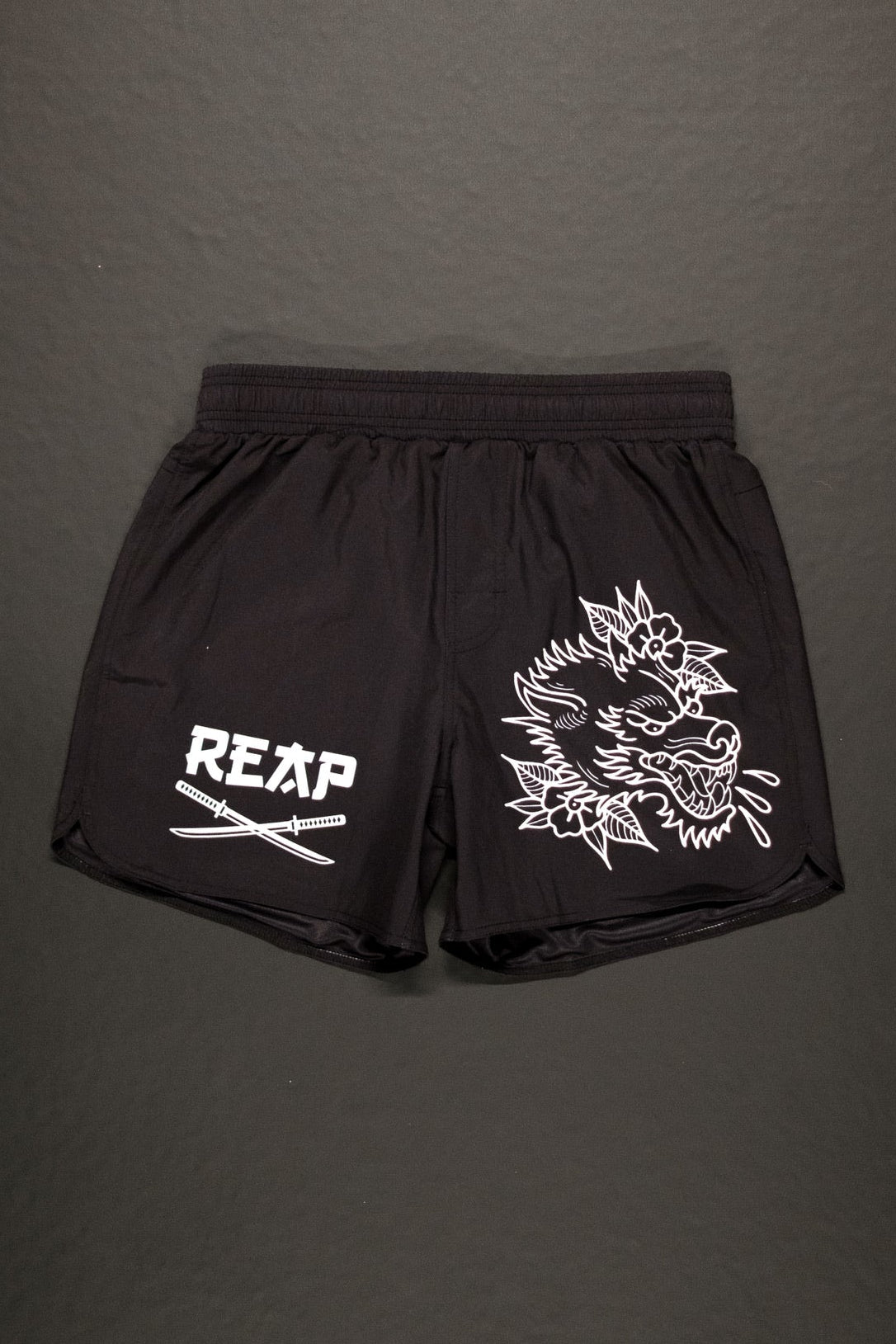 Black shorts with white graphics and text on a gray background