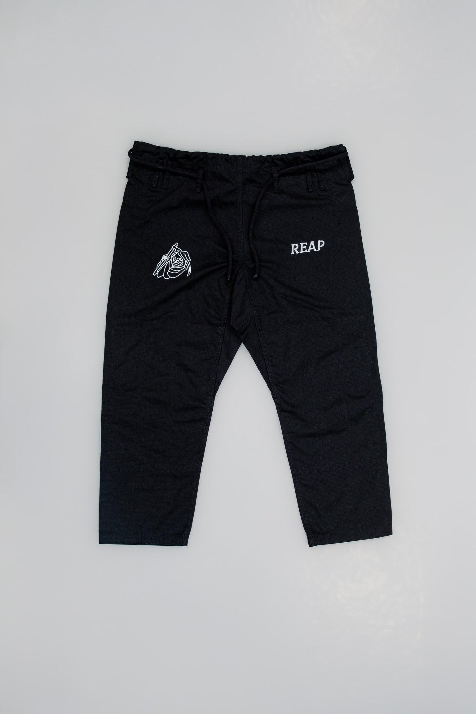 Black pants with logos on a light gray background