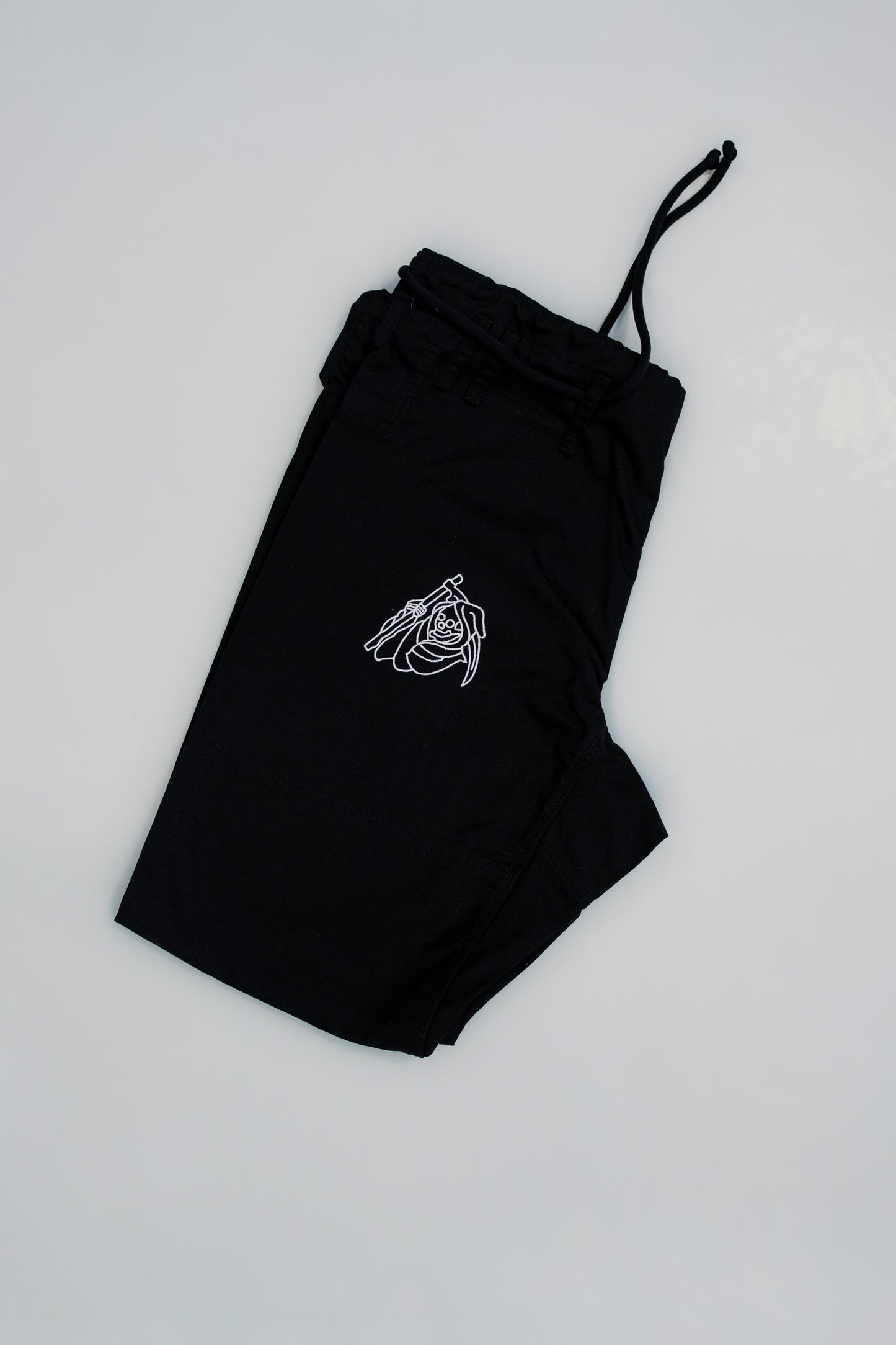 Black pants with a white logo on a light gray background