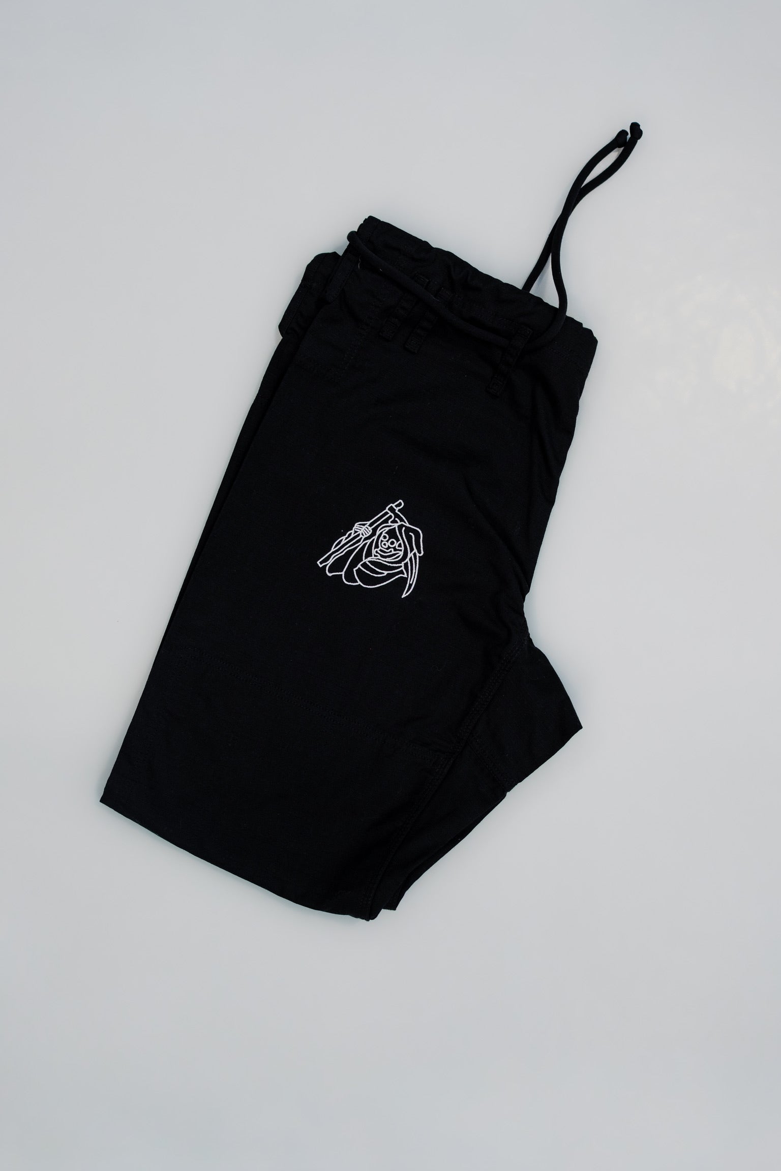 Black pants with a white logo on a light gray background