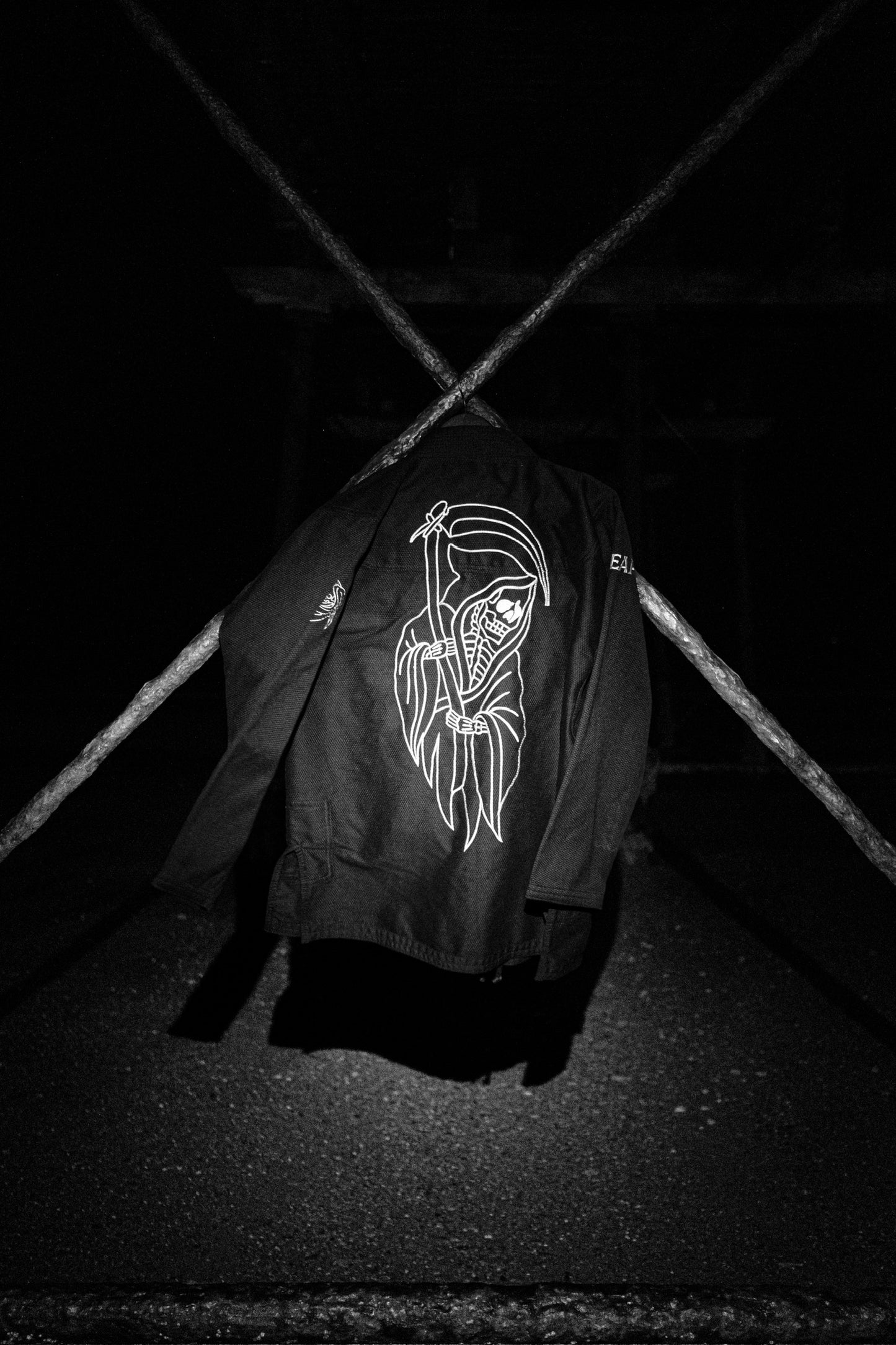 Black Gi jacket with white graphic design on a dark background