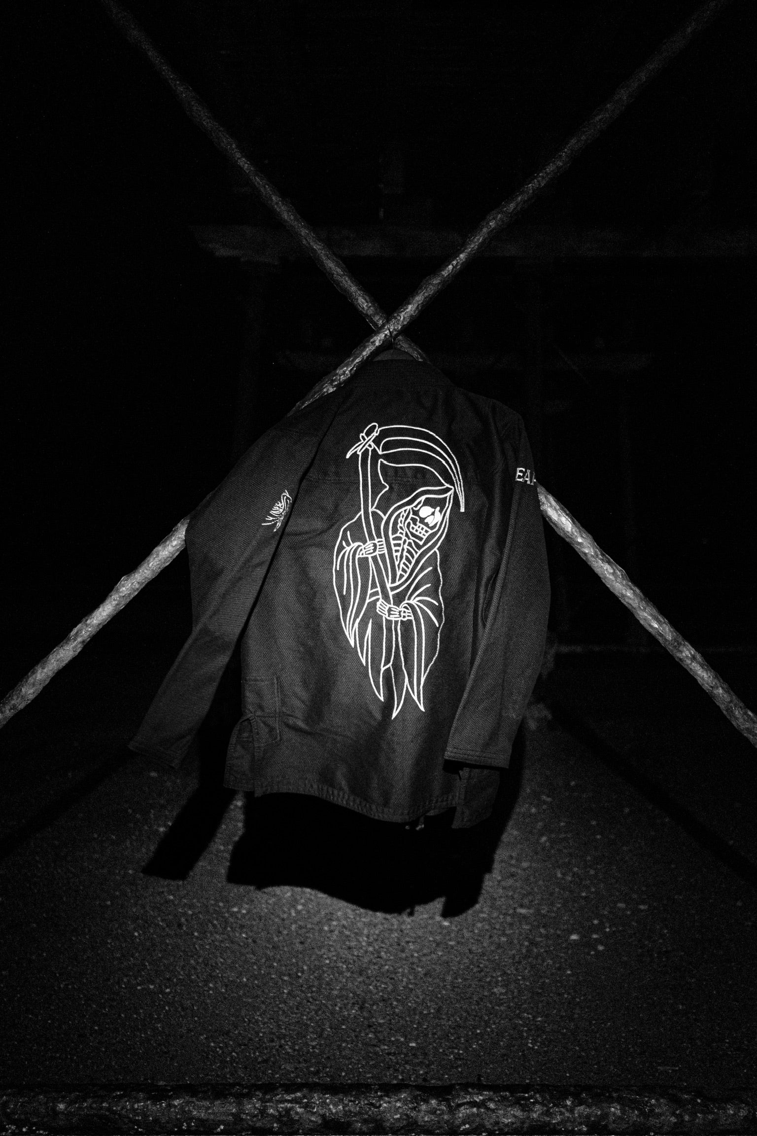 Black Gi jacket with white graphic design on a dark background