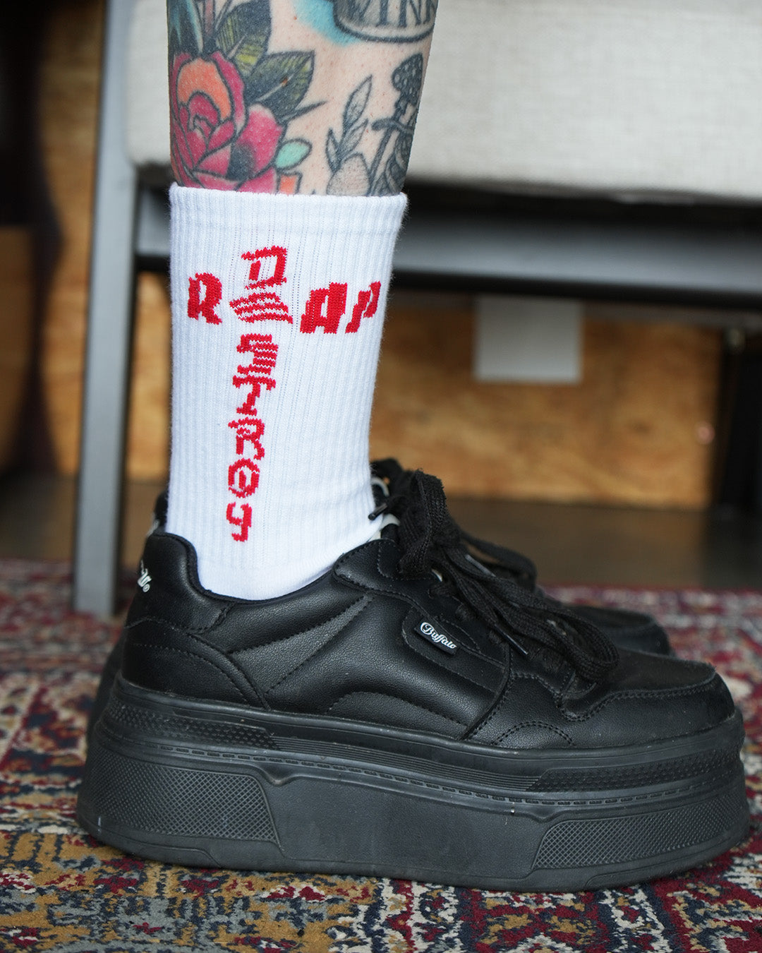 Reap and Destroy white BJJ socks with bold red print on both sides, worn